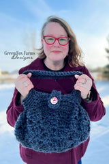 woman holding a dark blue crocheted hobo handbag with a button closure thumbnail