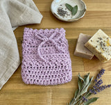 handmade lavender crochet lather sack with soap and dried lavender on a wooden surface thumbnail