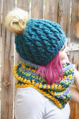 person wearing a teal alpine stitch crochet beanie with a faux fur pom pom outdoors thumbnail