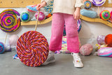 Jumbo yarn lollipop decoration upside down with a kid holding the stick thumbnail