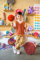 Kid holding jumbo lollipop crafts surrounded by candy decorations thumbnail