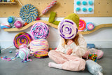 Little girl holding jumbo lollipop decoration in front of her face thumbnail
