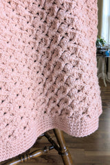close-up of pink crochet baby blanket draped over chair thumbnail