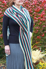 woman wearing a long teal, white, and red striped crocheted super scarf wrap outdoors thumbnail