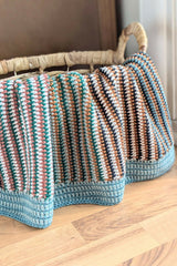 crochet baby blanket draped over a wooden chair thumbnail