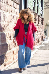 woman standing on sidewalk wearing a poncho thumbnail