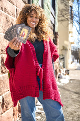 woman wearing poncho holding up tarot cards thumbnail