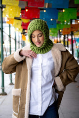 Woman in a granny square crochet hood looking down thumbnail