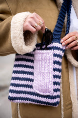 closeup of sunglasses being placed in simple striped bag thumbnail