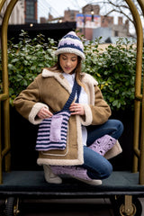 model wearing statement hat, simple striped bag, and granny motif legwarmers.  thumbnail