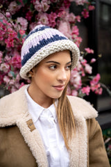 model wearing knit hat in front of flowers thumbnail