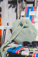 bag on a chair with sunglasses in front of it thumbnail