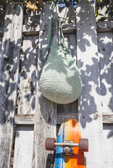 bag hanging on a fence over a skateboard thumbnail