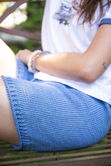 Woman sitting on a bench wearing blue knit shorts thumbnail