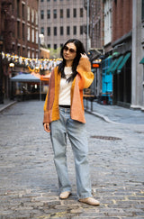 Woman wearing color changing cardigan on cobblestone street thumbnail