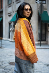 Woman wearing color changing cardigan on cobblestone street thumbnail