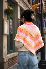 woman wearing orange, pink, cream shawl showing the point in the back thumbnail