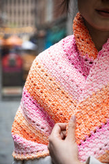 Close up of woman wrapped in colorful crochet shawl thumbnail