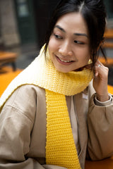 close up of smiling woman wearing yellow gradient crochet scarf thumbnail