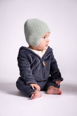 baby wearing knit hat in front of white background thumbnail