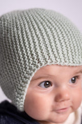 close up of baby wearing knit hat in front of white background thumbnail