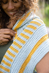 Woman wearing yellow and blue hooded scarf close up thumbnail
