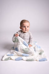 baby posing with granny square blanket wrap made with green blue and white yarns thumbnail