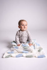 baby posing with granny square blanket wrap made with green blue and white yarns thumbnail