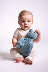 baby holding blue knit kitty lovey in front of white background thumbnail