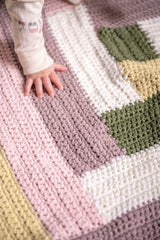 closeup of multicolor log cabin crochet blanket in front of white background thumbnail