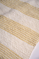 close up of knit yellow and cream striped blanket in front of a white background thumbnail
