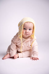 baby wearing white and yellow baby hat with ear flaps thumbnail