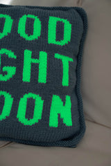 blue knit pillow with glow in the dark white letters that spell Good Night Moon thumbnail