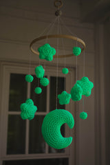 Crochet mobile hanging in front of a window showing the glow in the dark effect thumbnail