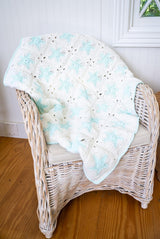 White granny square blanket with blue glow in the dark stars and border on a chair thumbnail
