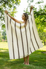 Cream and brown throw being held up by a woman  thumbnail