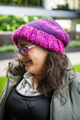 side view of woman wearing knit hat in pink and purple thumbnail