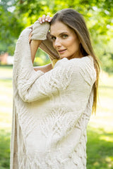 Woman wrapped in off white tree of life knit blanket showing the tree design thumbnail