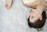 woman laying on tree of life blanket thumbnail