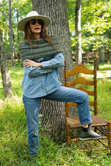 Woman wearing green cowl in the woods thumbnail