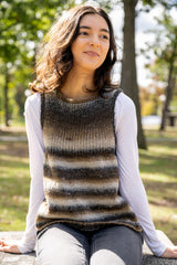 person wearing a brown and cream striped knit tank top and white shirt outdoors in a park thumbnail