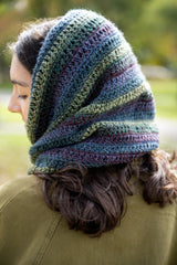person wearing a multicolored cowl and olive jacket outdoors thumbnail