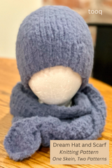 blue knitted wrap scarf and matching beanie displayed on a white foam mannequin head resting on a wooden surface thumbnail