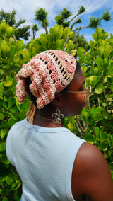 pink and cream yarn hat with floral patterns and textured details worn over the head thumbnail