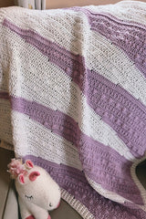 Purple and white baby blanket draped on a chair thumbnail