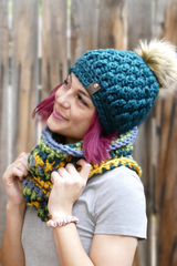 person wearing a teal alpine stitch crochet beanie with a faux fur pom pom outdoors thumbnail