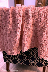pink blanket draped over back of chair thumbnail