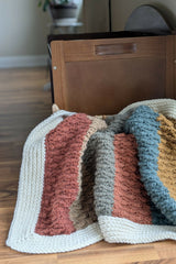 striped crochet blanket with white border in basket thumbnail
