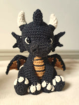 crochet amigurumi stuffed animal of a dragon black orange and cream thumbnail