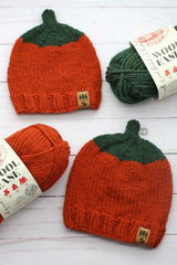 two knitted orange pumpkin beanies with orange and green yarn skeins thumbnail